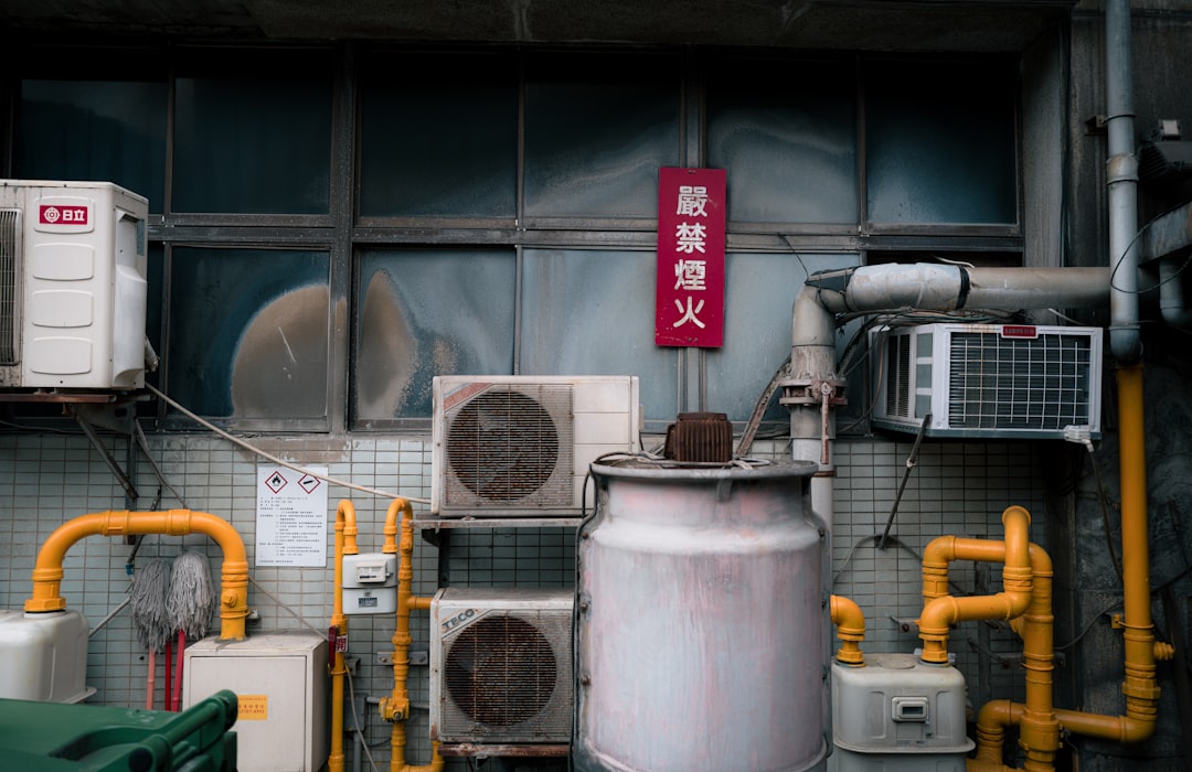 Outdoor air conditioning units mounted on exterior wall with pipes