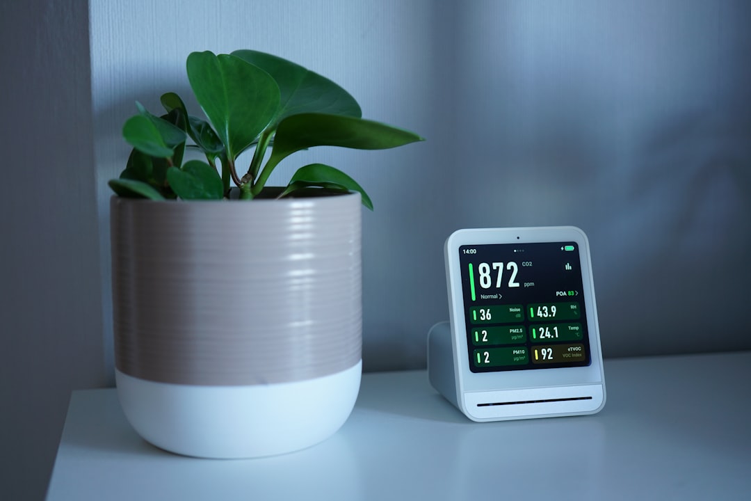 Home air quality monitor displaying PM2.5, CO2, and humidity readings on a shelf